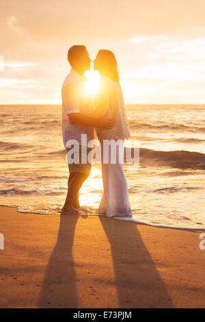 Romantische älteres Paar küssen bei Sonnenuntergang am Strand Stockfoto