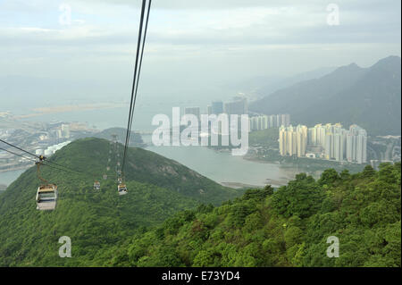 Blick vom Ngong Ping 360 Seilbahn Sessellift mit Tung Chung (rechts) im Abstand Stockfoto