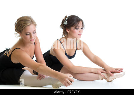 Zwei schöne junge Mädchen machen stretching Übung oder Teilungen zusammen isoliert Stockfoto