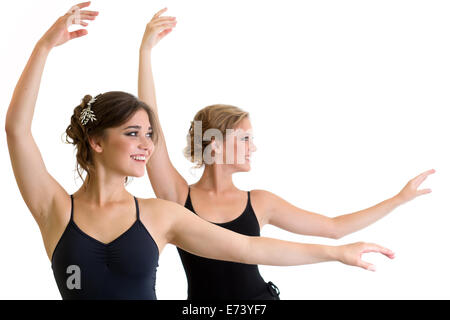 Zwei schöne junge Mädchen machen Sport oder tanzen zusammen isoliert Stockfoto