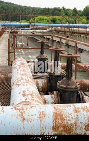 Rusty Armaturen Ventile Tor und Rohre in einer Wasseraufbereitungsanlage und flüssigen Drecksackblase. Stockfoto