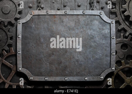 Metallplatte hängen an Ketten über mittelalterliche Getriebe und Zahnräder Stockfoto