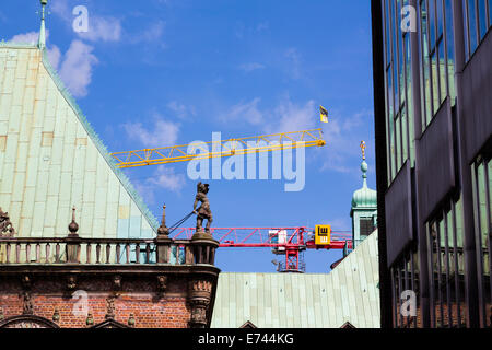 Moderne Baukrane hinter Bremer Rathaus mit Reflexionen aus dem Landtag-Gebäude. Stockfoto