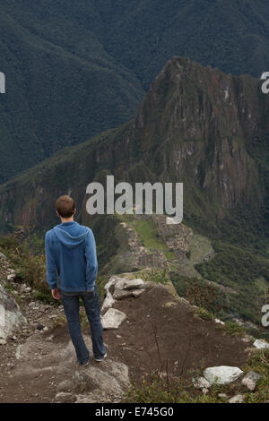 Ein Tourist genießt die herrliche Aussicht auf Machu Picchu Sanctuary von Berges Gipfel von Machu Picchu in Peru. Stockfoto