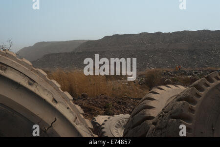 Mit Blick auf ein mittlerer Größe-Mining-Volvo-Bagger im Hintergrund durch verschrotteten Bergbau-LKW-Reifen LKW-Verladung. Stockfoto