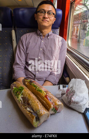 Perpignan, Frankreich, Portrait Chinese Tourist man im French Train mit Mittagessen, essen Sandwiches, vielfältige Reisende Stockfoto
