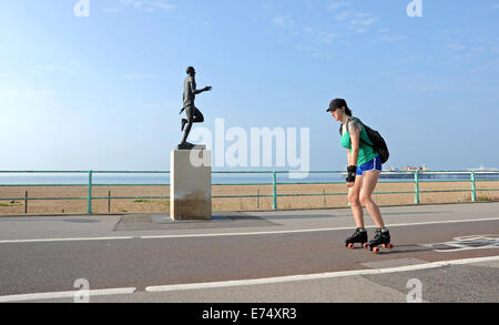 Brighton, Sussex, Großbritannien. September 2014. Wetter: Ein Rollschuhläufer passiert die Steve Ovett Statue an Brighton Uferpromenade bei schönem warmen Sonnenschein am frühen Morgen. Die Prognose wird in den nächsten Tagen im Südosten fair sein. Credit: Simon Dack/Alamy Live News Stockfoto