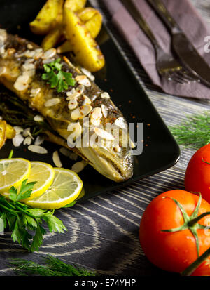 Gebratene Forelle mit Mandeln, Dill und Potato wedges Stockfoto