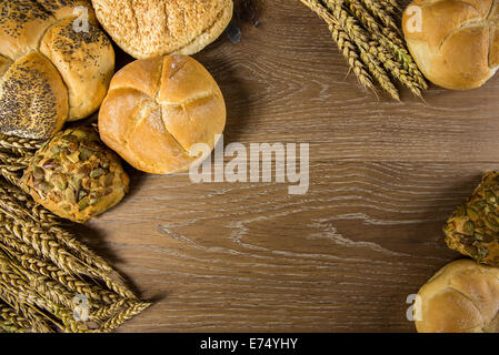 Verschiedene Art von frisch gebackenes Brot und Brötchen auf Holztisch Stockfoto