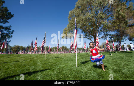 Kinder laufen durch ein Feld von amerikanischen Flaggen in Freedom Park in Ridgecrest, Kalifornien. Stockfoto