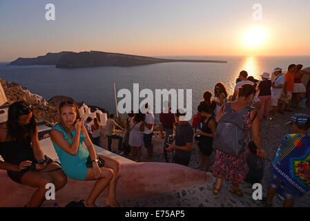 Touristen, die den weltberühmten Sonnenuntergang von Oia auf Santorin, Griechenland. Stockfoto