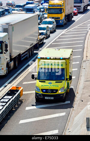 Rettungswagen mit Autobahn-Standspur zur Unfallstelle vor festgefahrene Autobahnverkehr zu erreichen Stockfoto