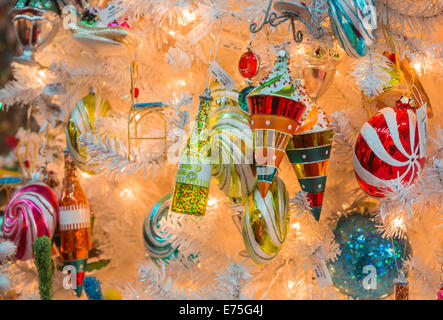 Festlicher Weihnachtsschmuck Urlaub auf einem weißen Weihnachtsbaum in einem Schaufenster in New York City, USA in leuchtenden Farben Stockfoto