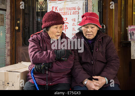 Zwei ältere Frauen sitzen und reden in Chinatown, San Francisco. Stockfoto