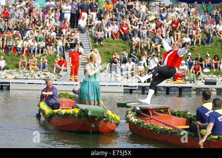 Der Bauer (Bauer) Walter Meisel (rechts) wird von seiner Frau (Bäuerin) Dominique Thomas (links) ins Wasser geschoben. Fünfzehn Mannschaften, jeweils bestehend aus 2 Ruderer und ein Mann mit einer Lanze, konkurrierten in den 65. Jahrestag Fischerstechen (Fischer Turnier) kämpfen statt am letzten Tag der Backfischfest. © Michael Debets/Pacific Press/Alamy Live-Nachrichten Stockfoto