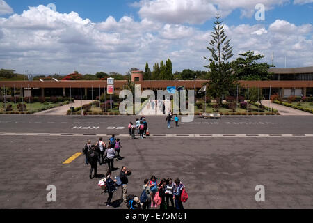 Eine Gruppe von Touristen geht zum Terminalgebäude nach der Landung im Flughafen Kilimanjaro in der Nähe von Arusha, Nord-Tansania Ostafrika Stockfoto