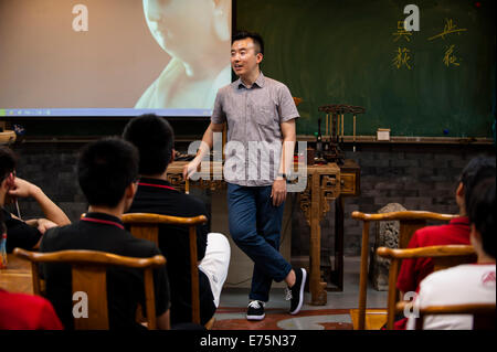 (140908)--Peking, 8. September 2014 (Xinhua)--Kunstlehrer Wu Di gibt die erste Klasse dieses Semesters zu seinen Studenten an der Experimental High School Beijing Nomral Universität angeschlossen in Peking, Hauptstadt von China, 3. September 2014. Wu Di ist eine erlernte Kunstlehrer arbeiten mit der Experimental High School angebracht zu Beijing Normal University. Unterdessen ist Wu, der in einer Vielzahl von traditionellen chinesischen Künsten geübt ist, als ein Meister der Malerei Klassenzimmer "Cheng Guan Tang" und ein Superstar des Geschichtenerzählens Haus "Cheng Shu Guan" bekannt. Mit den Schwerpunkten in der traditionellen chinesischen Malerei in der Schule Stockfoto