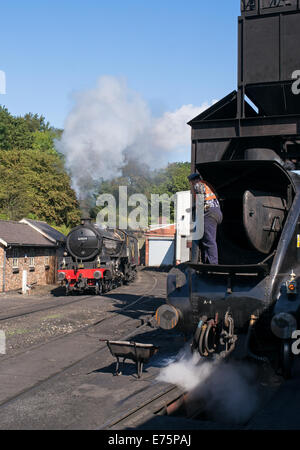 Eine Footplateman beobachtet, wie ein Dampf Zug fährt vorbei an NYMR Grosmont, North Yorkshire, England, UK Stockfoto