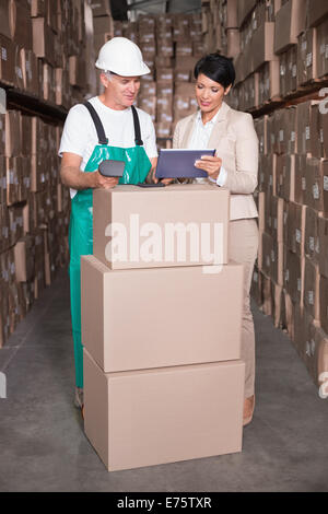 Lager Arbeiter Box mit Manager hält TabletPC Scannen Stockfoto