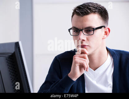 Junger Mann an einem Computer arbeiten Stockfoto