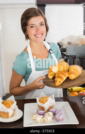 Hübsche Kellnerin mit Tablett mit croissants Stockfoto