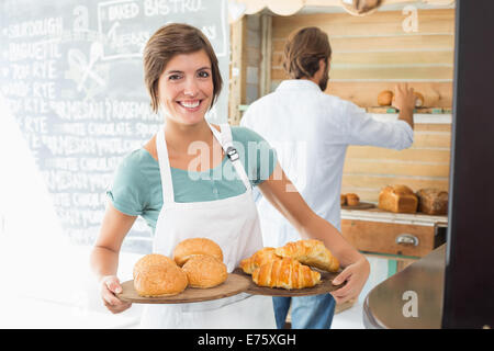 Hübsche Barista hält Tabletts von Backwaren Stockfoto