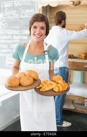 Hübsche Barista hält Tabletts von Backwaren Stockfoto