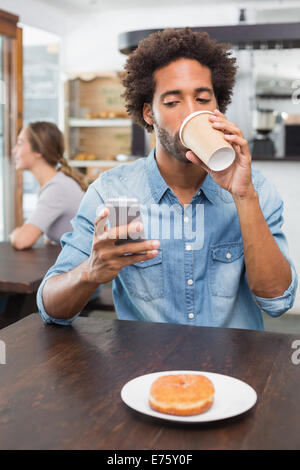 Gut aussehender Mann SMS Kaffeetrinken Stockfoto