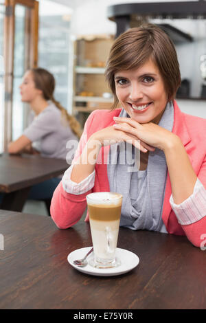 Hübsche Brünette ihre Latte genießen Stockfoto