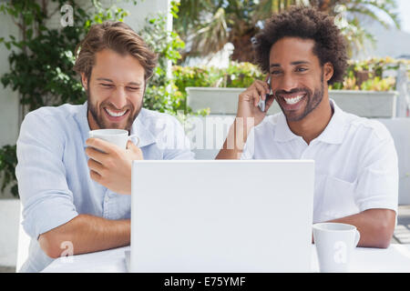 Glückliche Freunde genießen Kaffee zusammen mit laptop Stockfoto