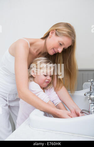 Glückliche Mutter und Tochter, die Hände zu waschen Stockfoto