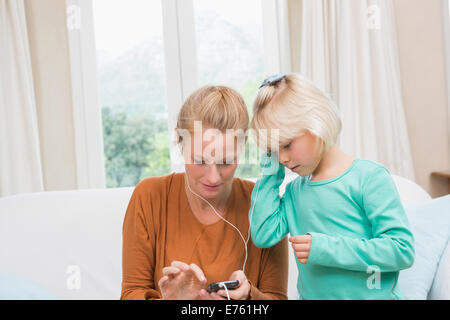 Glückliche Mutter und Tochter anhören von Musik Stockfoto