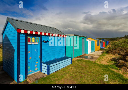 CHALETS IM HOPEMAN STRAND MORAY REIHEN VON MULTI-COLOURED HÜTTEN IN DER SONNE NACH DEM REGEN Stockfoto