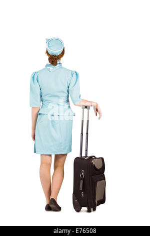 Hübsche Stewardess stützte sich auf Koffer Stockfoto