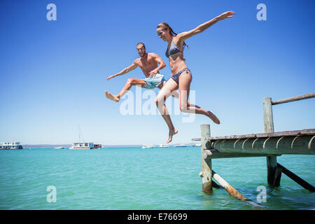 Paar aus hölzernen Dock ins Wasser springen Stockfoto