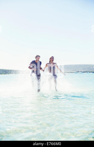 Paar, planschen im Wasser am Strand Stockfoto