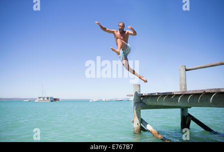 Paar aus hölzernen Dock ins Wasser springen Stockfoto