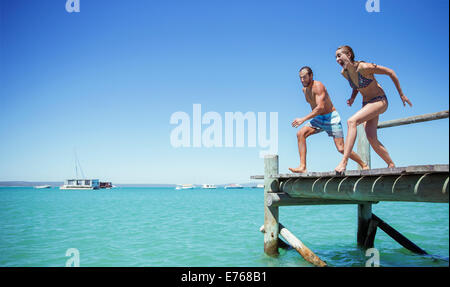 Paar springen aus hölzernen Dock zusammen Stockfoto