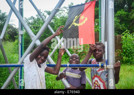 Lächelnde angolanischen Kinder posieren mit der Flagge Angolas Stockfoto