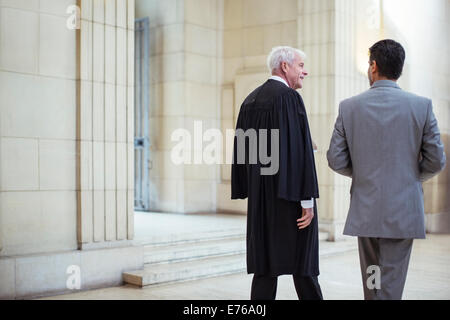 Richter und Anwalt zu Fuß durch Gerichtsgebäude zusammen Stockfoto