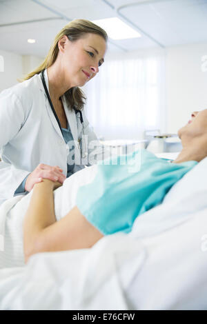 Arzt im Gespräch mit Patienten im Krankenzimmer Stockfoto