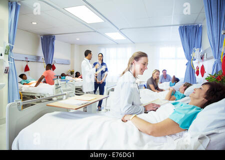 Ärzte, Krankenschwestern und Patienten im Krankenzimmer Stockfoto