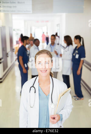 Arzt im Krankenhaus Flur lächelnd Stockfoto