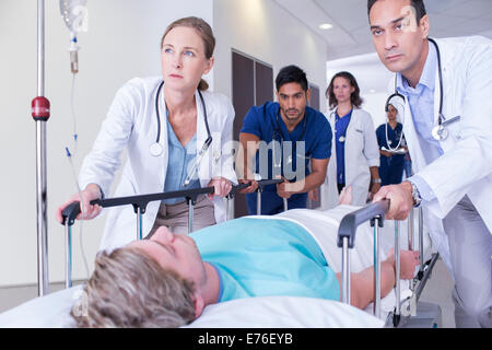 Ärzte, die Patienten im Krankenhaus Flur Machenschaften Stockfoto