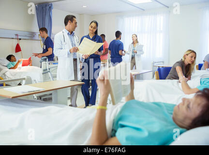 Ärzte, Krankenschwestern und Patienten im Krankenzimmer Stockfoto