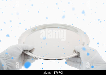 Zusammengesetztes Bild von behandschuhten Händen mit silbernen Tablett Stockfoto