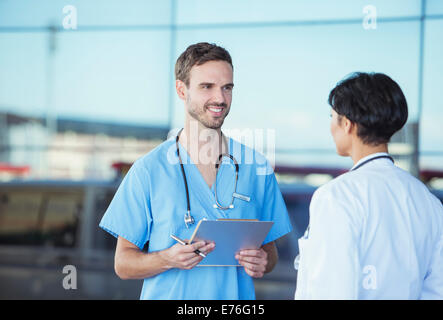 Arzt und Krankenschwester sprechen außerhalb Krankenhaus Stockfoto