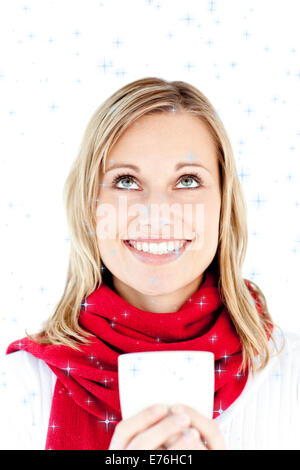 Zusammengesetztes Bild der glückseligen junge Frau hält eine Tasse trägt einen Schal Stockfoto