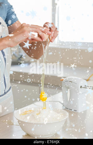 Zusammengesetztes Bild des Innenfeldes Frau knacken ein Ei in die Schüssel in Küche Stockfoto