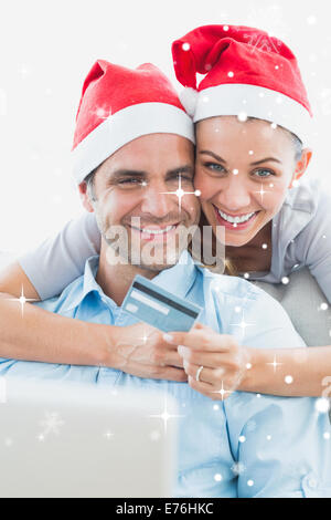 Zusammengesetztes Bild des glücklichen Paares in Santa Hüte Online-shopping Stockfoto
